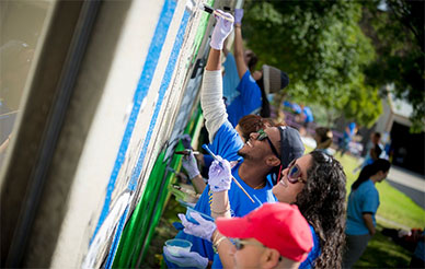Students doing community service and painting a mural
